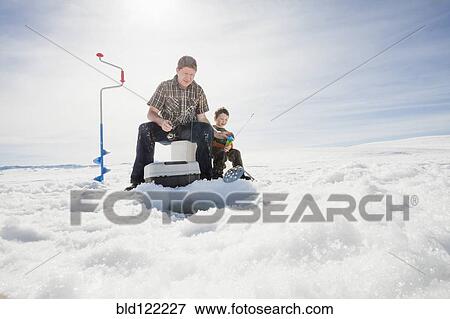 Stock Photo - Caucasian father and son ice fishing. Fotosearch