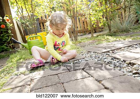Stock Photo - Caucasian girl playing in backyard. Fotosearch