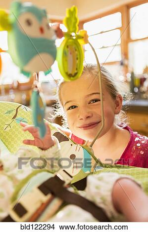 Picture - Caucasian girl playing with newborn baby brother. Fotosearch