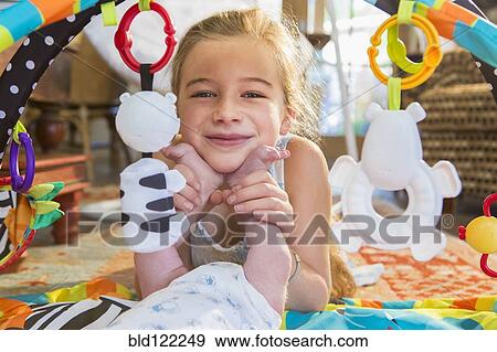 Stock Photo - Caucasian girl playing with newborn baby brother. Fotosearch