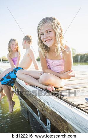Caucasian girl sitting on dock View Large Photo Image Stock Photograph - Caucasian girl sitting on dock. Fotosearch