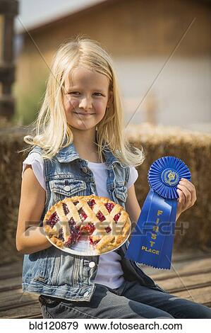 Stock Photo - Caucasian girl with prize winning pie on farm. Fotosearch