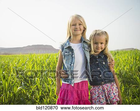 Stock Image - Caucasian girls smiling in corn field. Fotosearch