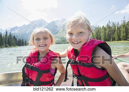Caucasian girls wearing life jackets in canoe View Large Photo Image Stock Image - Caucasian girls wearing life jackets in canoe. Fotosearch