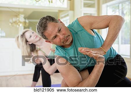 Stock Photography - Caucasian man practicing yoga in class. Fotosearch