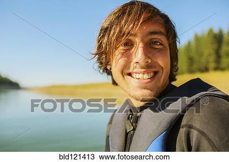 Caucasian man smiling by rural lake View Large Photo Image Stock Image - Caucasian man smiling by rural lake. Fotosearch