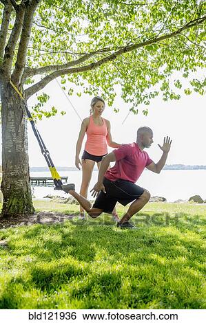 Stock Photograph - Caucasian man working with trainer outdoors. Fotosearch