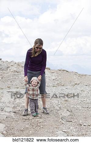 Stock Image - Caucasian mother and baby in rocky landscape. Fotosearch