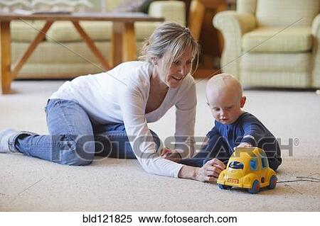 Caucasian mother and baby playing in living room View Large Photo Image Stock Photography - Caucasian mother and baby playing in living room. Fotosearch