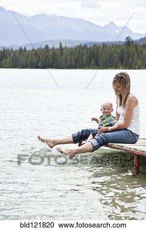 Caucasian mother and baby sitting by lake View Large Photo Image Stock Image - Caucasian mother and baby sitting by lake. Fotosearch