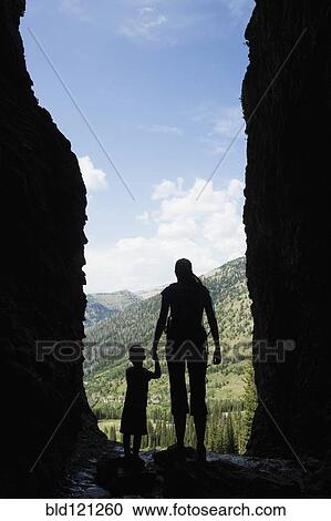 Stock Image - Caucasian mother and son exploring cave. Fotosearch