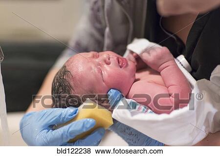 Stock Photo - Caucasian newborn baby boy having bath. Fotosearch