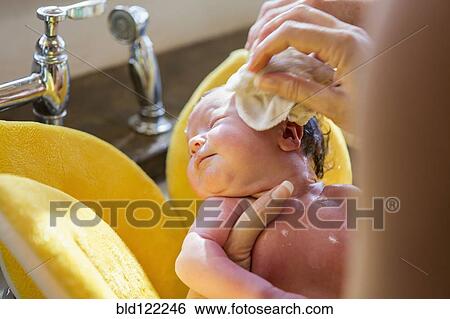 Stock Photograph - Caucasian newborn baby boy having bath. Fotosearch