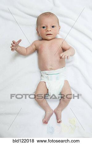 Stock Photo - Caucasian newborn boy laying on blanket. Fotosearch
