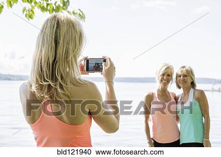 Caucasian woman photographing women outdoors View Large Photo Image Stock Image - Caucasian woman photographing women outdoors. Fotosearch