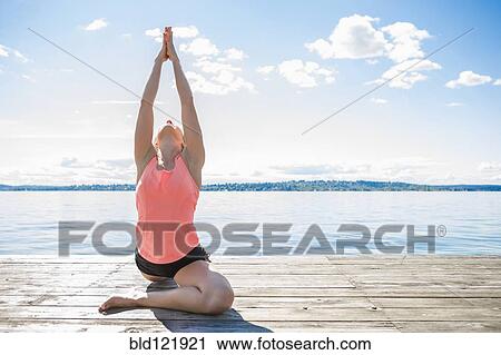 Caucasian woman practicing yoga on wooden dock View Large Photo Image Stock Image - Caucasian woman practicing yoga on wooden dock. Fotosearch