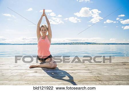 Caucasian woman practicing yoga on wooden dock View Large Photo Image Stock Image - Caucasian woman practicing yoga on wooden dock. Fotosearch