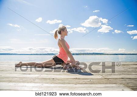 Caucasian woman practicing yoga on wooden dock View Large Photo Image Stock Image - Caucasian woman practicing yoga on wooden dock. Fotosearch
