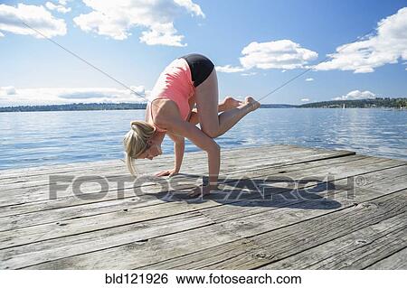 Caucasian woman practicing yoga on wooden dock View Large Photo Image Stock Photograph - Caucasian woman practicing yoga on wooden dock. Fotosearch