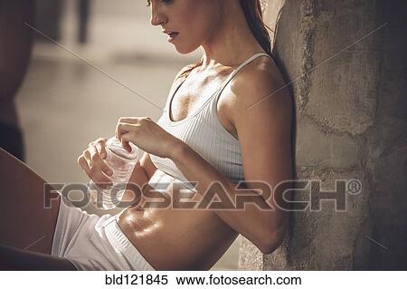 Stock Photography - Caucasian woman resting in gym. Fotosearch