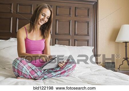 Caucasian woman using digital tablet in bed View Large Photo Image Stock Photo - Caucasian woman using digital tablet in bed. Fotosearch