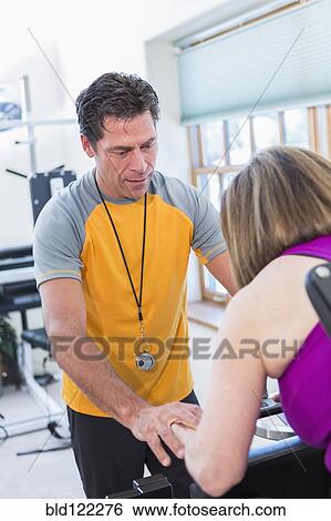 Caucasian woman working with personal trainer in gym View Large Photo Image Stock Photograph - Caucasian woman working with personal trainer in gym. Fotosearch