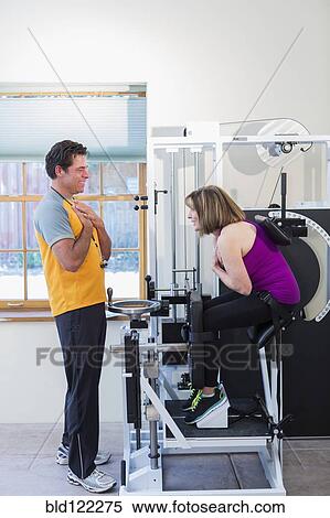 Caucasian woman working with personal trainer in gym View Large Photo Image Stock Photography - Caucasian woman working with personal trainer in gym. Fotosearch