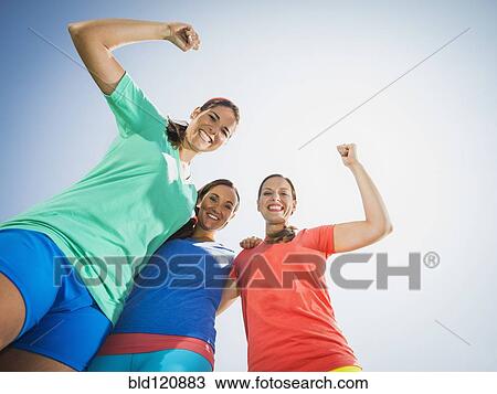Stock Image - Caucasian women cheering outdoors. Fotosearch