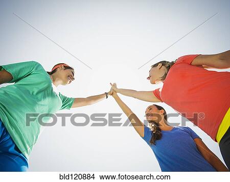 Caucasian women high fiving outdoors View Large Photo Image Picture - Caucasian women high fiving outdoors. Fotosearch