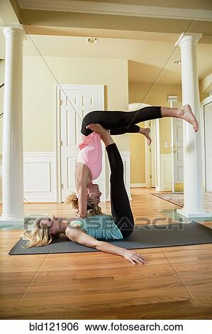 Caucasian women practicing acroyoga in home View Large Photo Image Stock Photograph - Caucasian women practicing acroyoga in home. Fotosearch