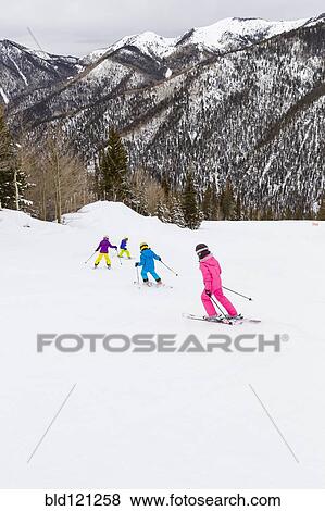 Stock Photo - Children skiing together on snowy slope. Fotosearch