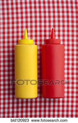 Stock Image - Close up of ketchup and mustard bottles. Fotosearch