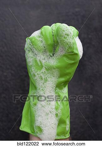 Stock Image - Close up of soap suds covering rubber glove. Fotosearch