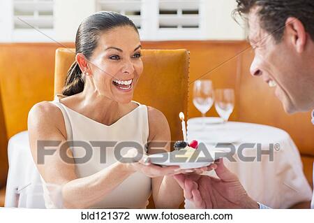 Stock Image - Couple celebrating birthday at restaurant. Fotosearch