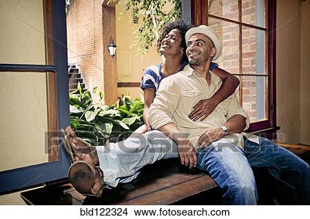 Couple relaxing together in windowsill View Large Photo Image Picture - Couple relaxing together in windowsill. Fotosearch