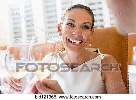Couple toasting each other at restaurant View Large Photo Image Stock Photo - Couple toasting each other at restaurant. Fotosearch