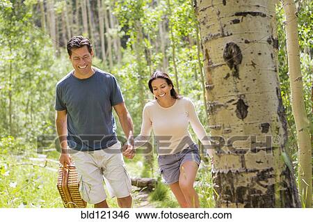 Stock Photograph - Couple walking together in forest. Fotosearch