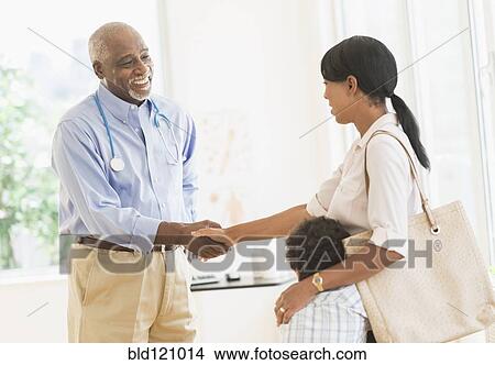 Picture - Doctor shaking mother's hand. Fotosearch