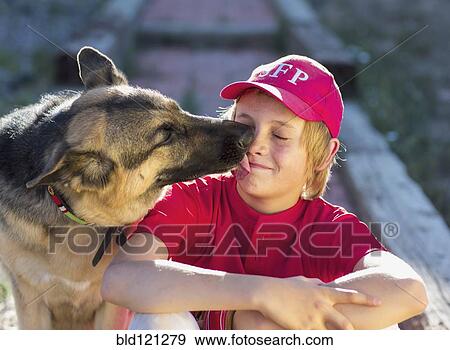 Stock Photo - Dog licking Caucasian boy's face. Fotosearch