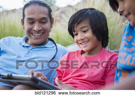 Family using digital tablet outdoors View Large Photo Image Stock Photograph - Family using digital tablet outdoors. Fotosearch