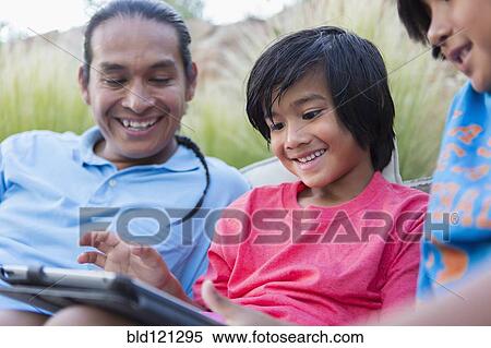 Family using digital tablet outdoors View Large Photo Image Stock Photography - Family using digital tablet outdoors. Fotosearch
