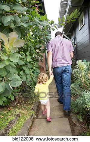 Father and daughter walking in backyard View Large Photo Image Stock Photograph - Father and daughter walking in backyard. Fotosearch