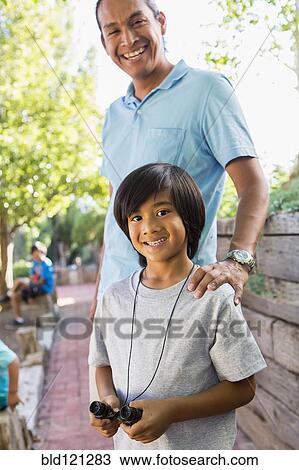Stock Image - Father and son smiling outdoors. Fotosearch