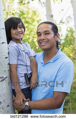 Stock Photograph - Father holding son outdoors. Fotosearch