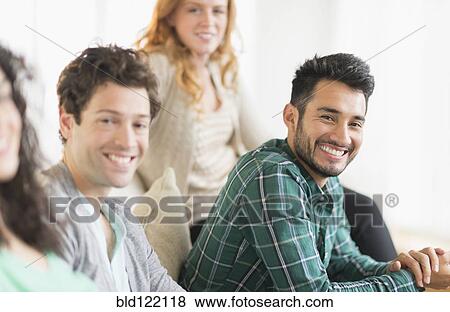 Friends relaxing together on sofa View Large Photo Image Stock Photo - Friends relaxing together on sofa. Fotosearch