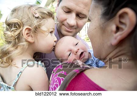 Stock Image - Girl kissing newborn brother. Fotosearch