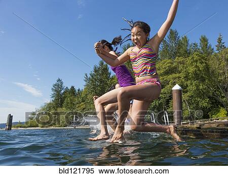 Girls jumping together into lake View Large Photo Image Stock Photography - Girls jumping together into lake. Fotosearch