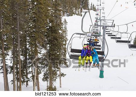 Girls riding ski lift on snowy slope View Large Photo Image Stock Image - Girls riding ski lift on snowy slope. Fotosearch