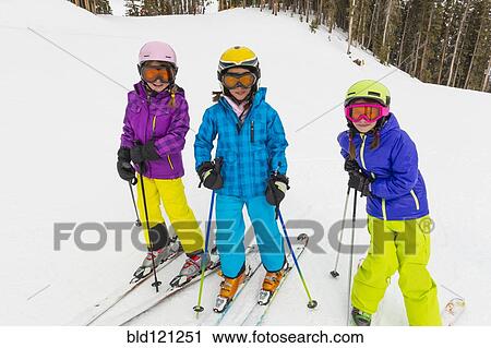 Stock Image - Girls skiing together on snowy slope. Fotosearch
