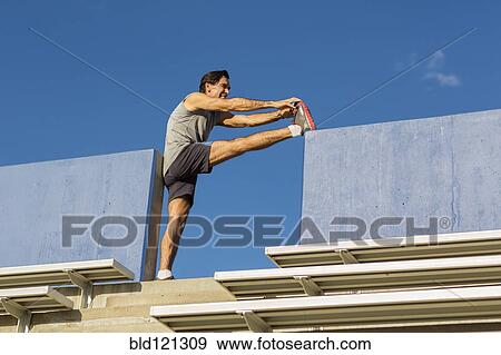 Hispanic athlete stretching on bleachers View Large Photo Image Stock Photo - Hispanic athlete stretching on bleachers. Fotosearch